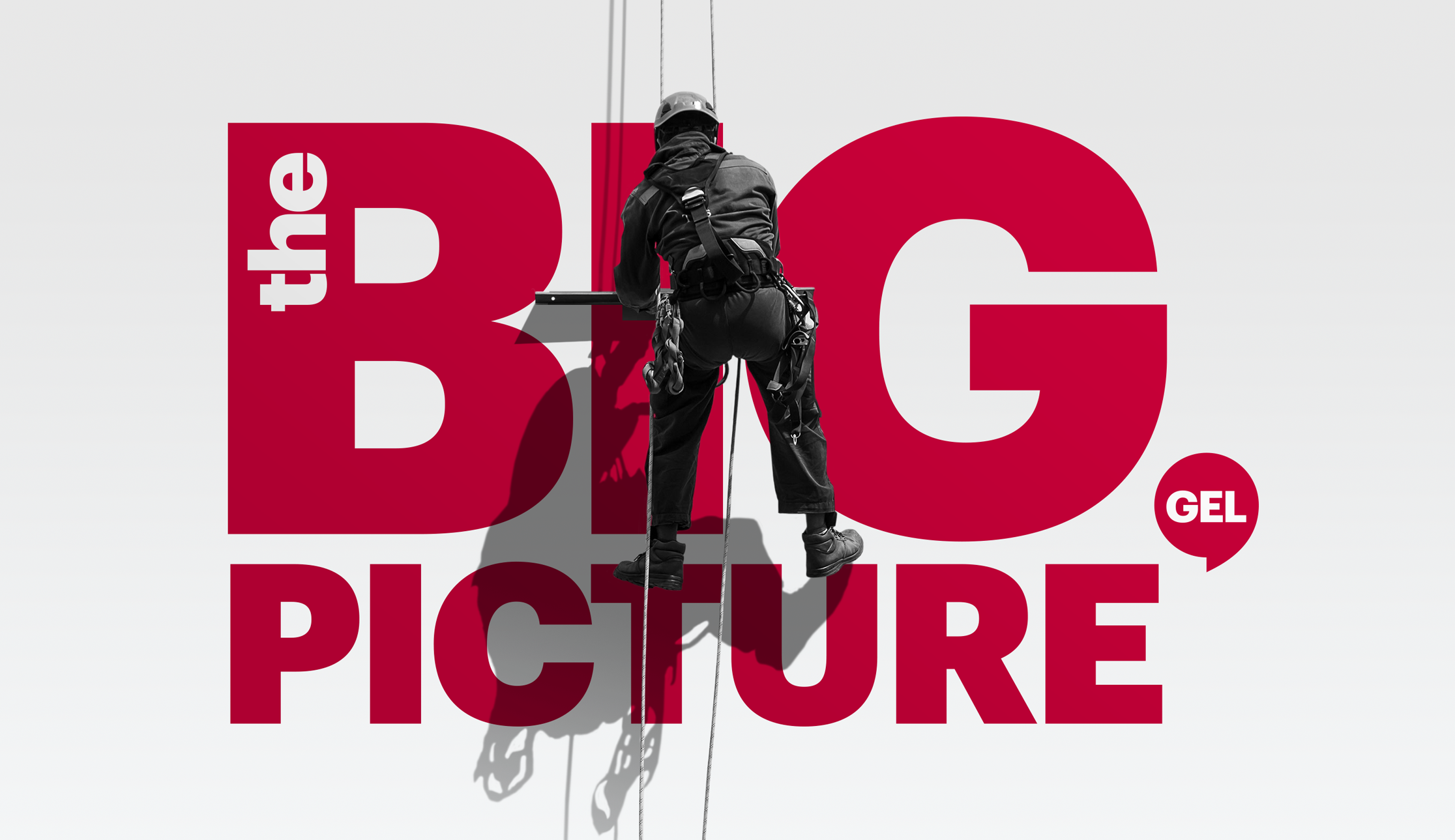 Window cleaner hanging in front of a big wall that says 'The big picture'.